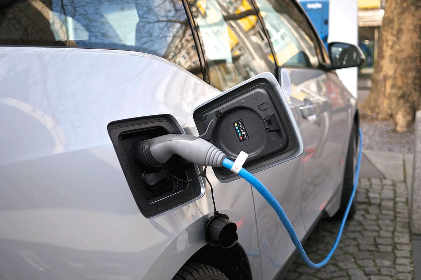 Blue EV charging cable connected to a white electric vehicle